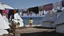 Child stands between tents at the new Lesvos camp