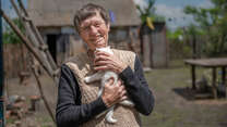 Anna stands holding her kitten.